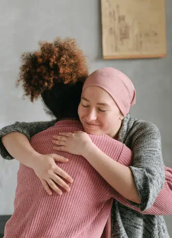 A cancer patient hugging their friend