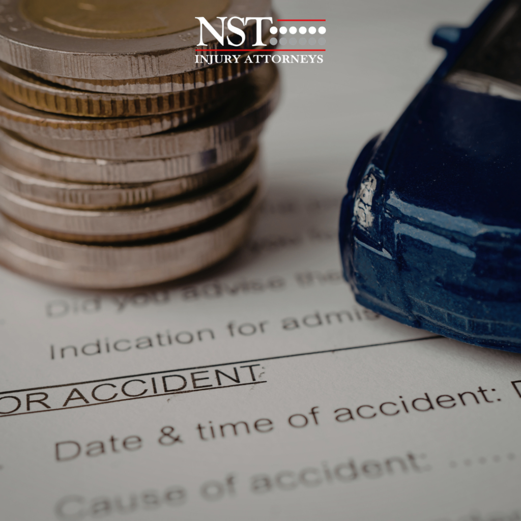Coins and a toy car on top of a car accident form