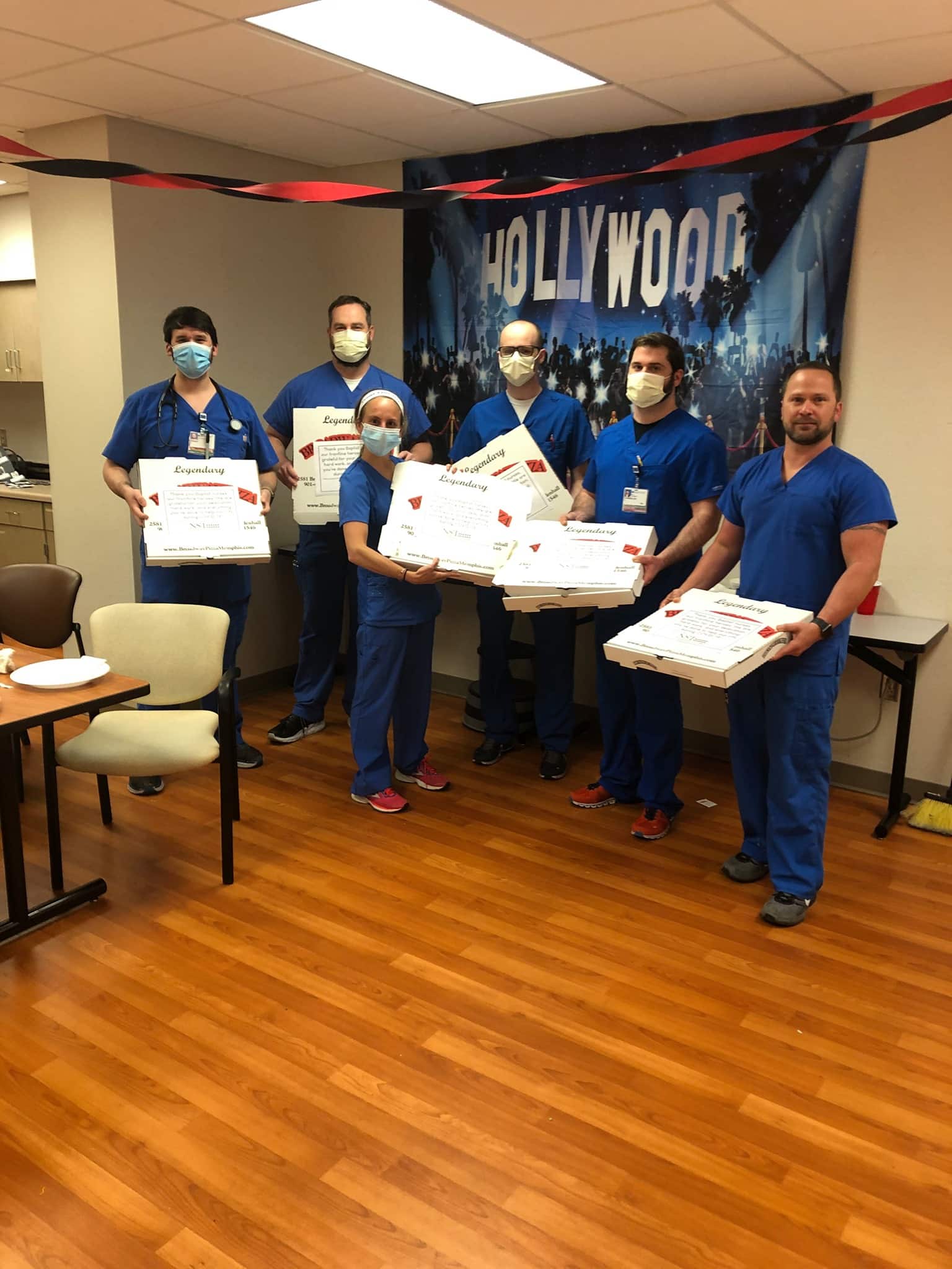 Nurses and doctors holding boxes of pizza