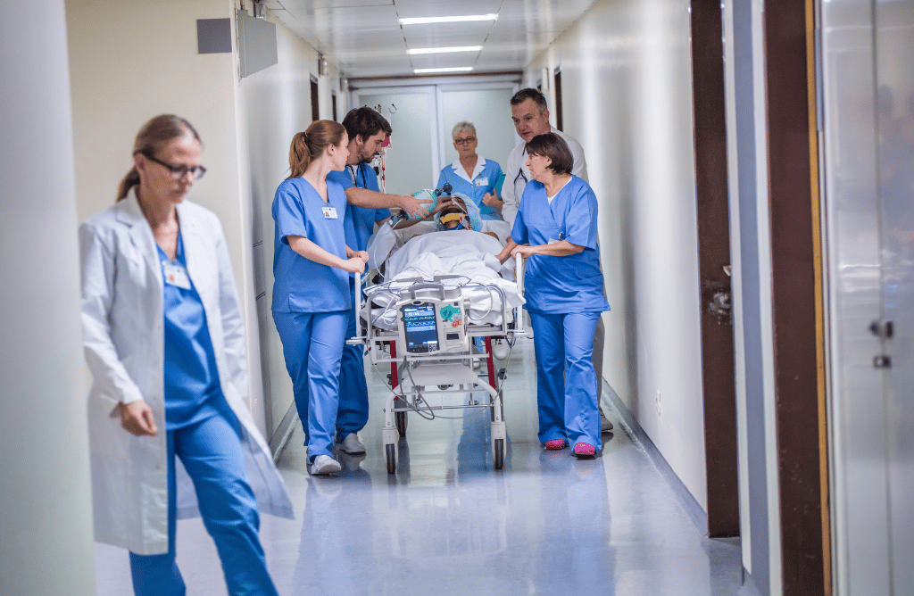 A photo of some hospital staff pushing a patient on a moving bed