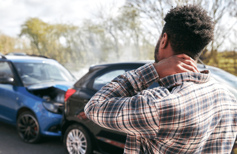 Photo of man holding his neck after a car accident