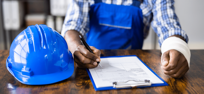 A construction worker signing a worker's compensation form