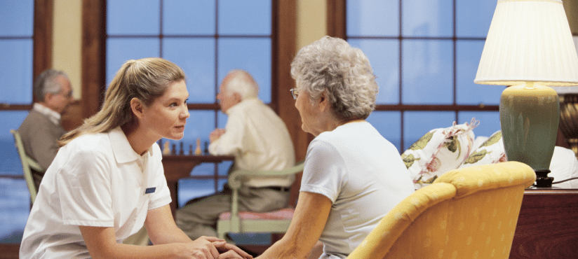 A grandmother and granddaughter talking in a retirement home